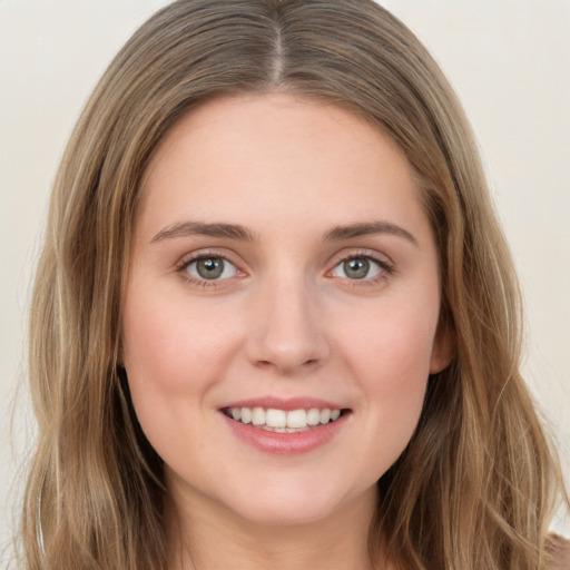 Joyful white young-adult female with long  brown hair and green eyes