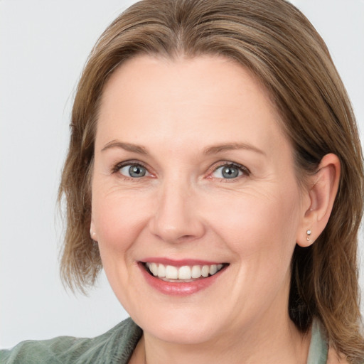 Joyful white adult female with medium  brown hair and blue eyes