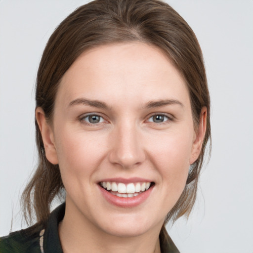 Joyful white young-adult female with medium  brown hair and grey eyes