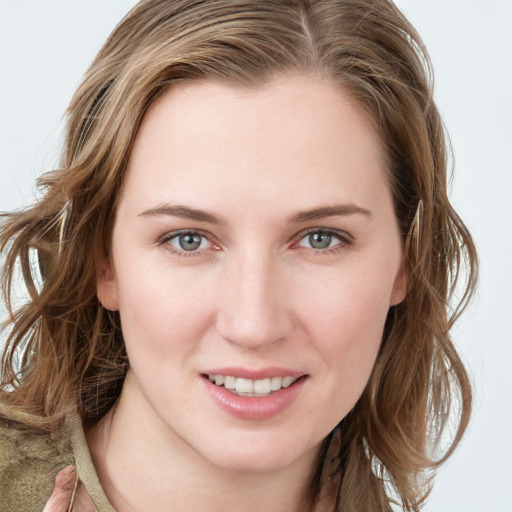 Joyful white young-adult female with long  brown hair and blue eyes