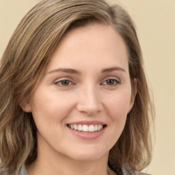 Joyful white young-adult female with long  brown hair and green eyes