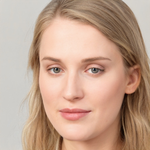 Joyful white young-adult female with long  brown hair and blue eyes