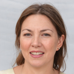 Joyful white adult female with medium  brown hair and grey eyes