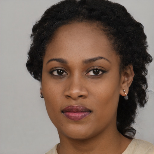 Joyful black young-adult female with short  black hair and brown eyes