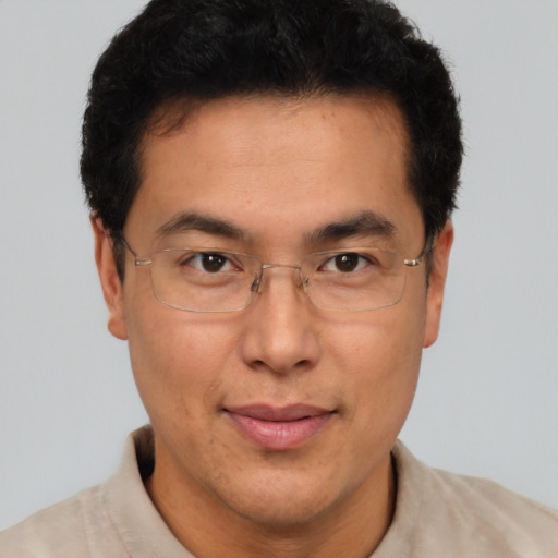 Joyful latino adult male with short  brown hair and brown eyes