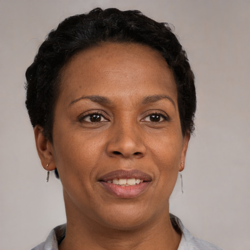 Joyful black adult female with short  black hair and brown eyes