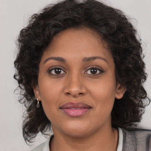 Joyful black young-adult female with medium  brown hair and brown eyes