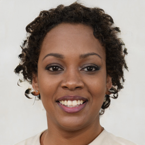 Joyful black young-adult female with short  brown hair and brown eyes
