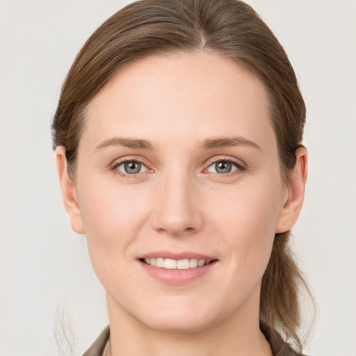 Joyful white young-adult female with medium  brown hair and grey eyes