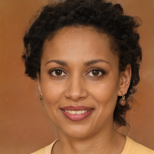 Joyful black young-adult female with medium  brown hair and brown eyes