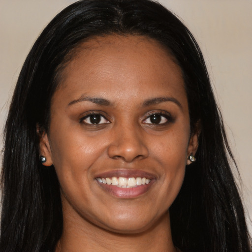 Joyful black young-adult female with long  brown hair and brown eyes