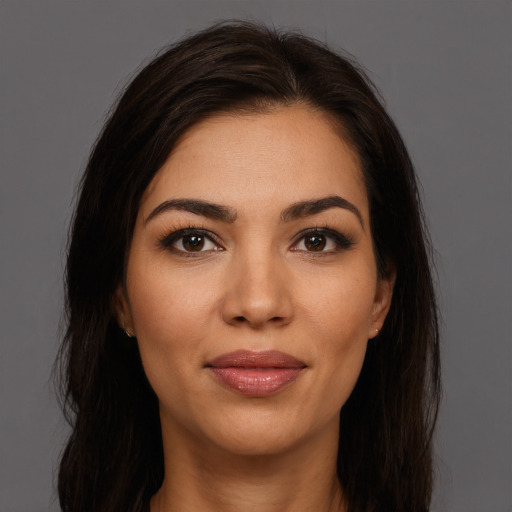 Joyful latino young-adult female with long  brown hair and brown eyes