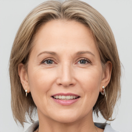 Joyful white adult female with medium  brown hair and grey eyes