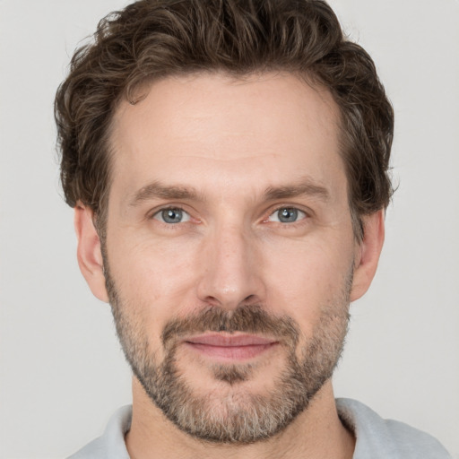 Joyful white adult male with short  brown hair and grey eyes