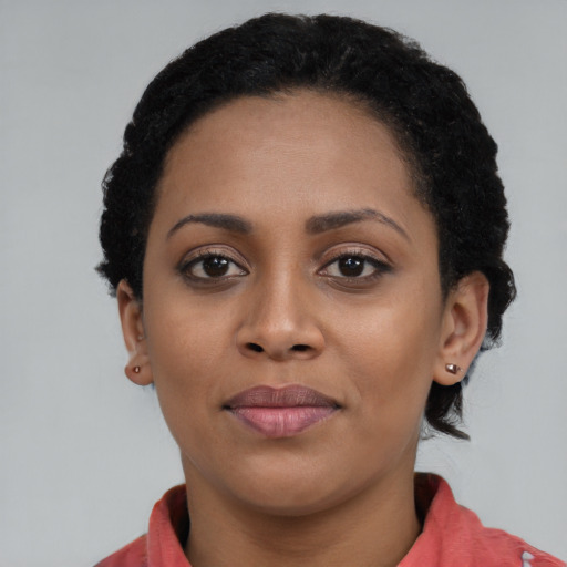 Joyful black young-adult female with short  black hair and brown eyes