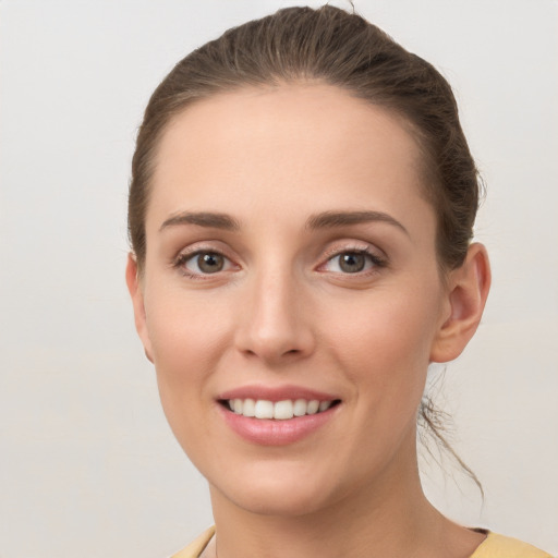 Joyful white young-adult female with short  brown hair and grey eyes