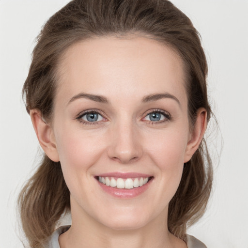 Joyful white young-adult female with medium  brown hair and grey eyes