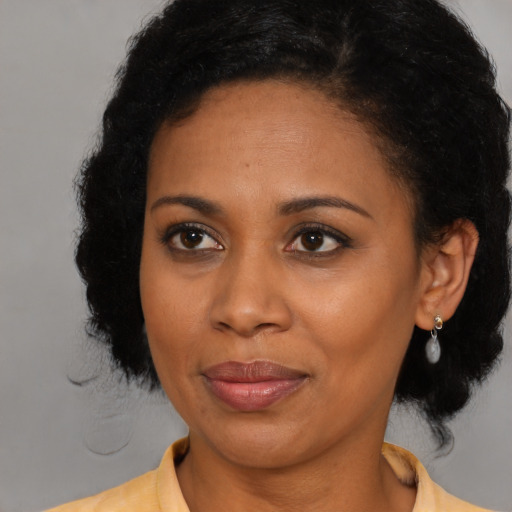 Joyful latino adult female with medium  brown hair and brown eyes