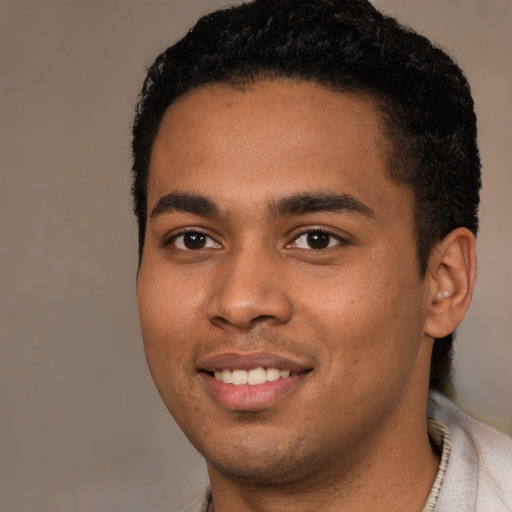 Joyful black young-adult male with short  black hair and brown eyes