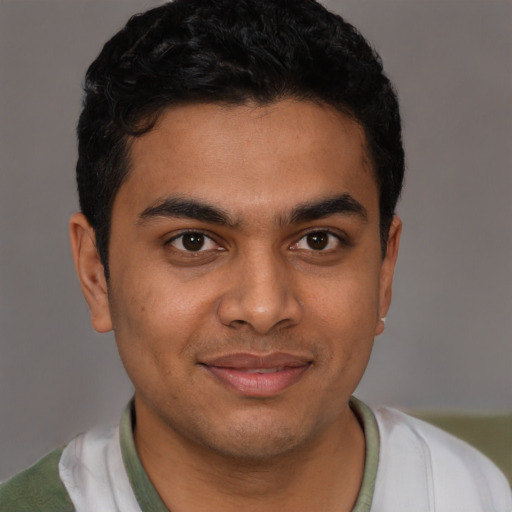 Joyful latino young-adult male with short  black hair and brown eyes