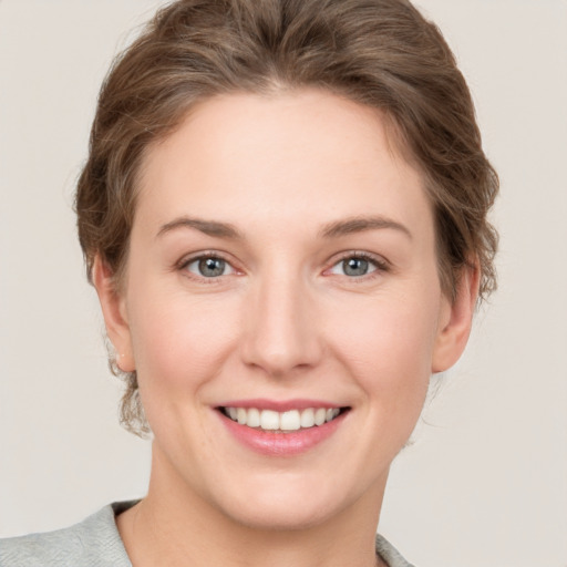 Joyful white young-adult female with short  brown hair and grey eyes