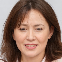 Joyful white adult female with long  brown hair and brown eyes