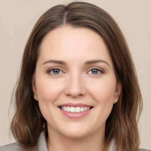 Joyful white young-adult female with medium  brown hair and green eyes