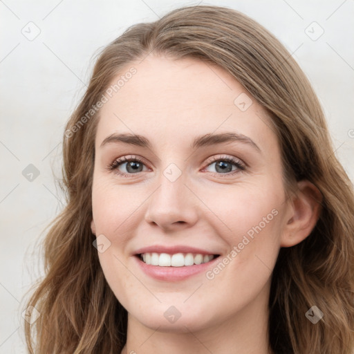 Joyful white young-adult female with long  brown hair and blue eyes