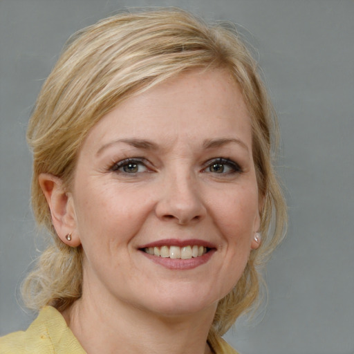 Joyful white adult female with medium  brown hair and blue eyes