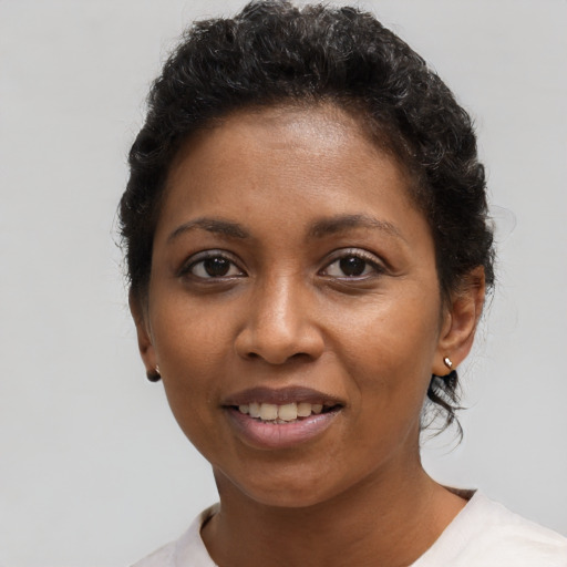 Joyful black young-adult female with short  black hair and brown eyes