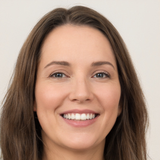 Joyful white young-adult female with long  brown hair and green eyes