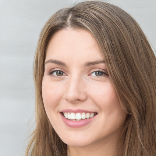 Joyful white young-adult female with long  brown hair and green eyes