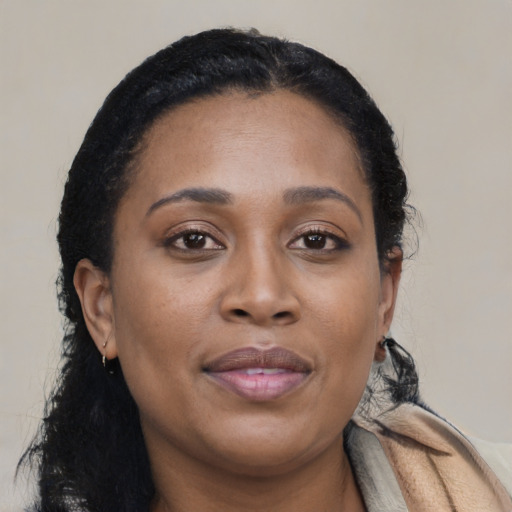 Joyful black young-adult female with long  brown hair and brown eyes
