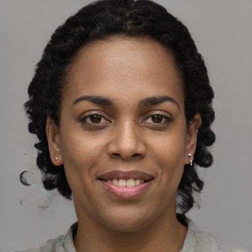Joyful black young-adult female with short  brown hair and brown eyes