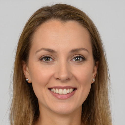 Joyful white young-adult female with long  brown hair and brown eyes