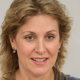 Joyful white adult female with medium  brown hair and green eyes