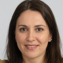 Joyful white adult female with long  brown hair and brown eyes