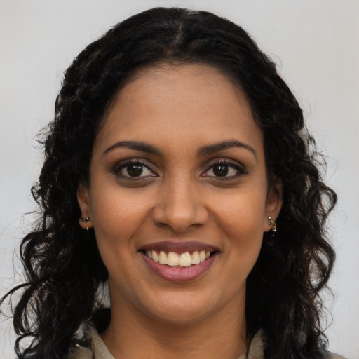 Joyful black young-adult female with long  black hair and brown eyes