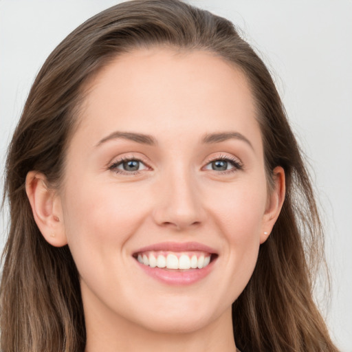 Joyful white young-adult female with long  brown hair and blue eyes