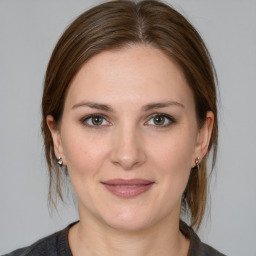 Joyful white young-adult female with medium  brown hair and grey eyes