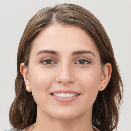 Joyful white young-adult female with medium  brown hair and grey eyes