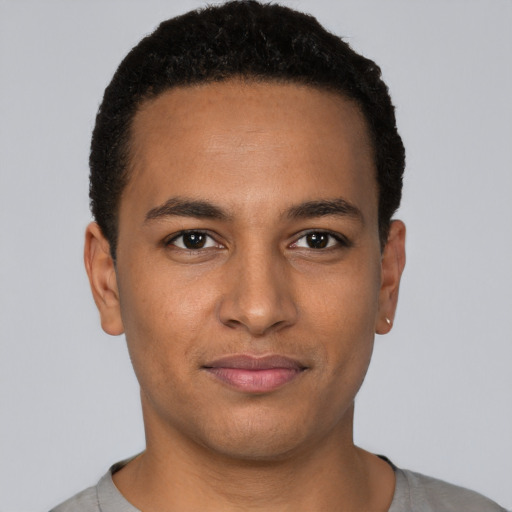 Joyful black young-adult male with short  brown hair and brown eyes