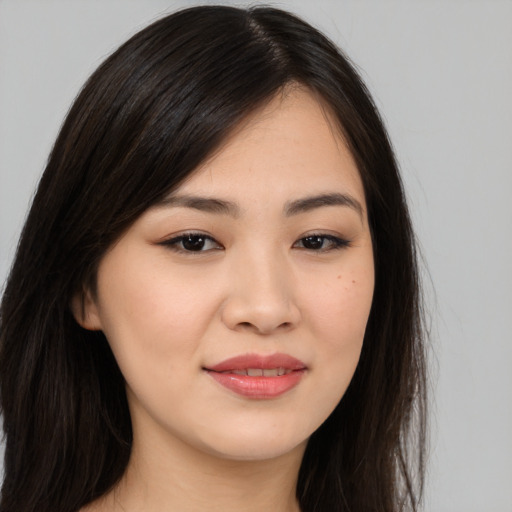 Joyful asian young-adult female with long  brown hair and brown eyes