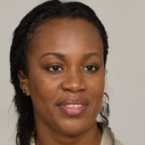 Joyful black young-adult female with long  brown hair and brown eyes