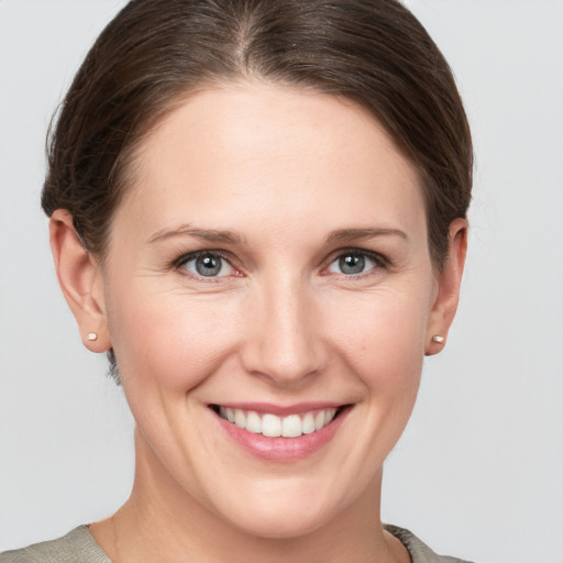 Joyful white young-adult female with short  brown hair and grey eyes