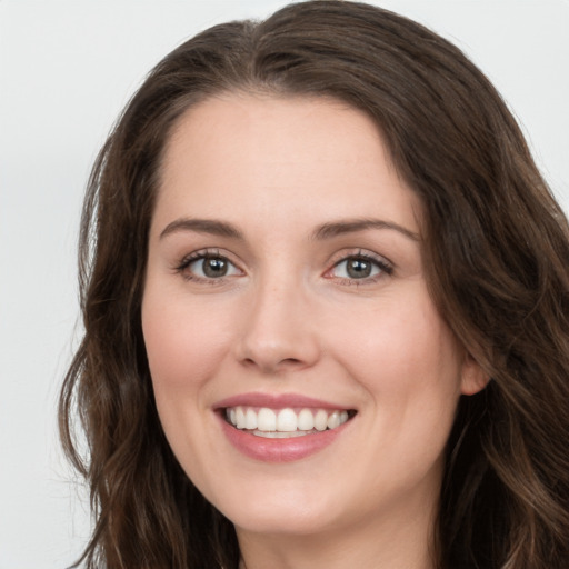 Joyful white young-adult female with long  brown hair and grey eyes