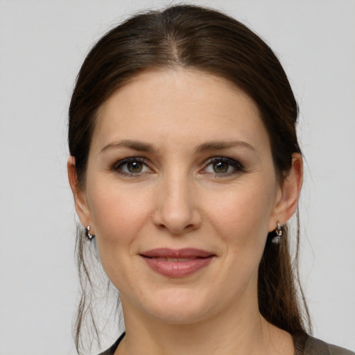 Joyful white young-adult female with medium  brown hair and grey eyes