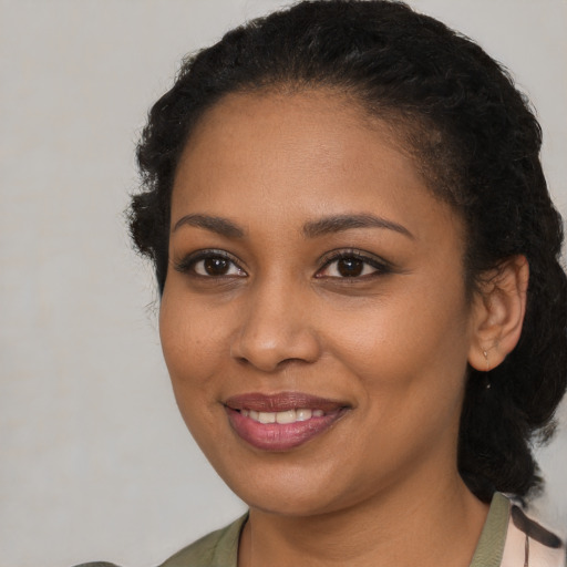 Joyful black young-adult female with medium  black hair and brown eyes