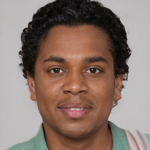 Joyful black young-adult male with short  brown hair and brown eyes