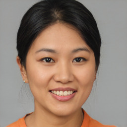 Joyful asian young-adult female with medium  brown hair and brown eyes